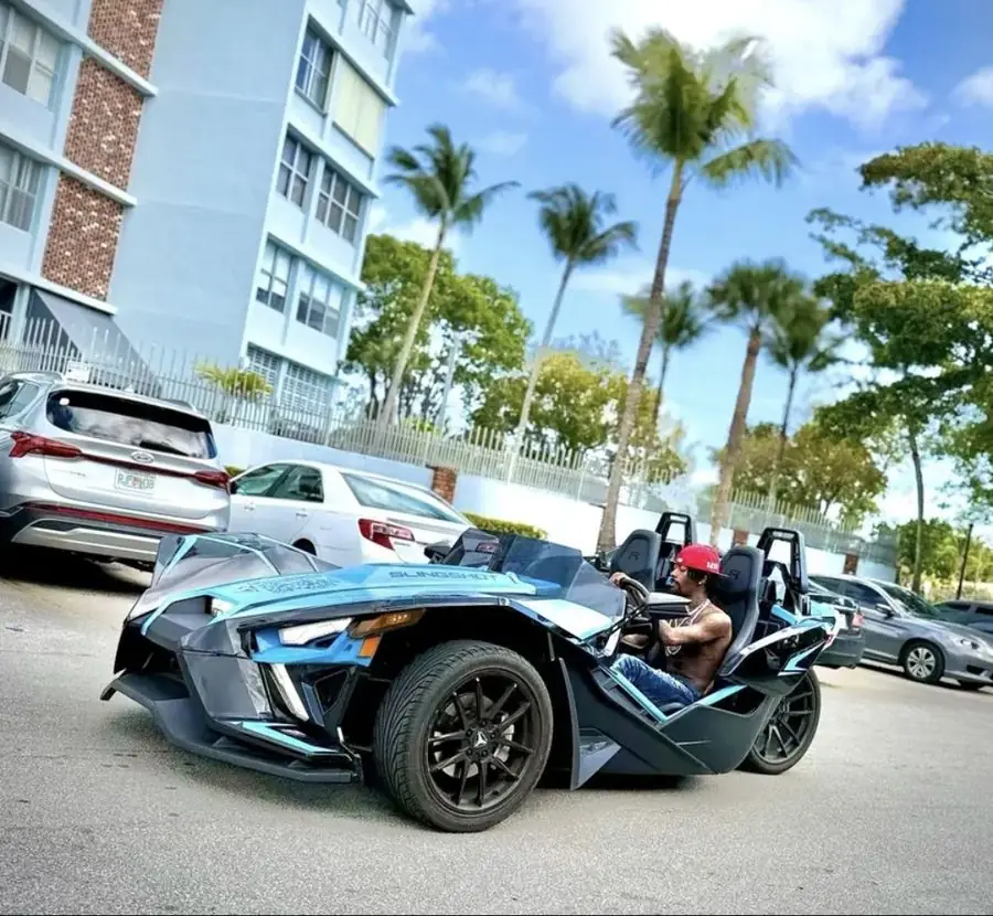 Blue Slingshot Miami โ man driving open-air on Miami streets