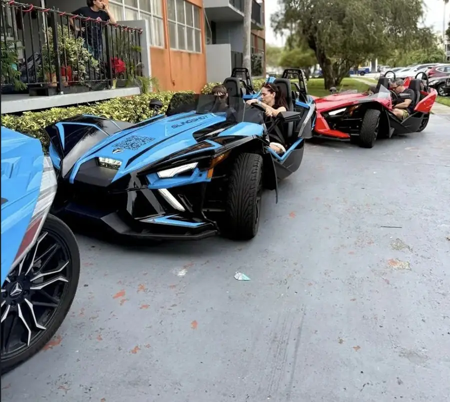 Green Polaris Slingshot rental Miami โ smiling customers